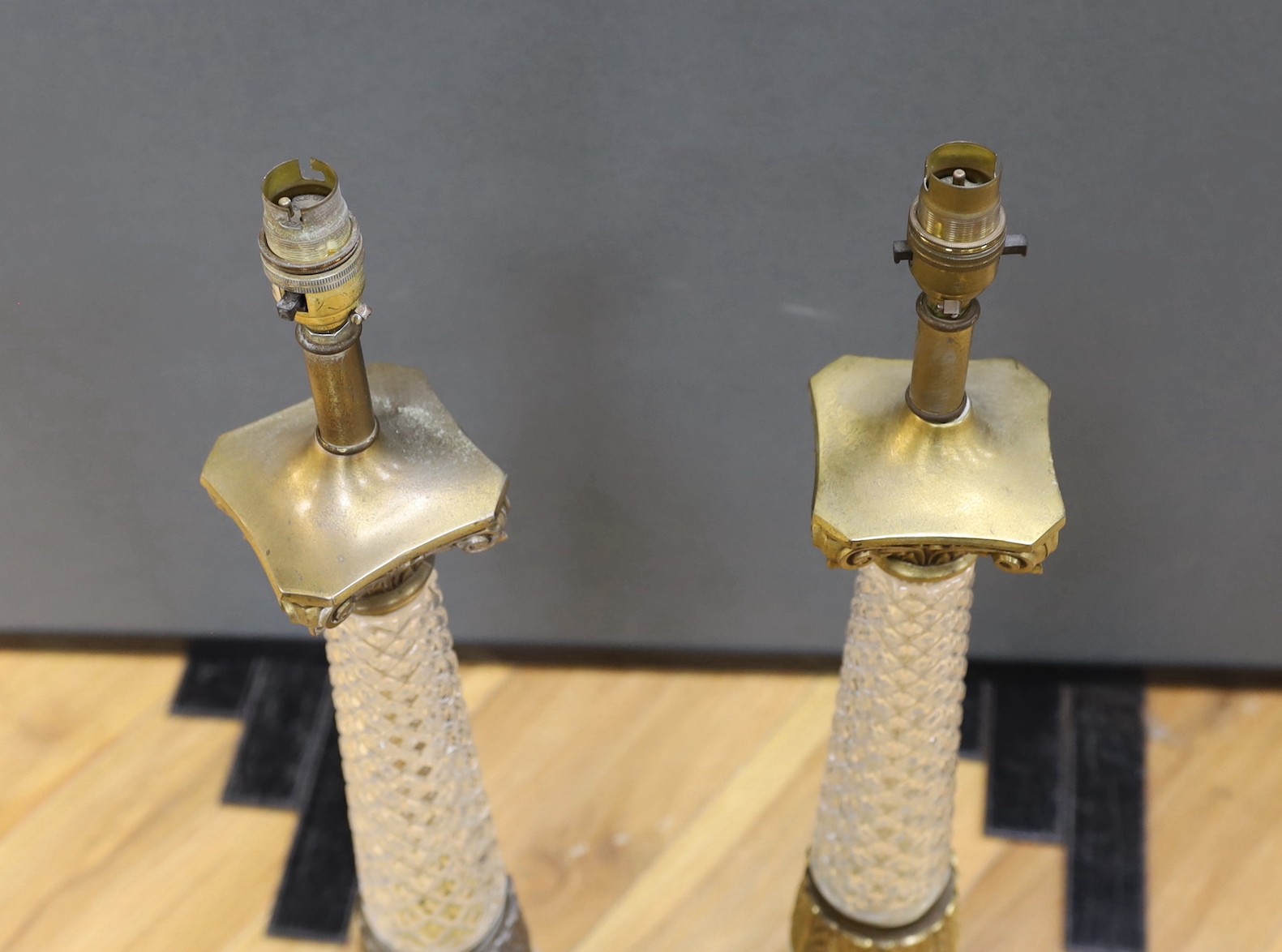 A pair of gilt brass and glass lamps with shades, 71cms high including light fitting